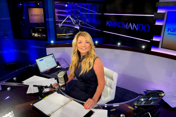 Tech expert Kim Komando sitting at a desk, discussing financial scams
