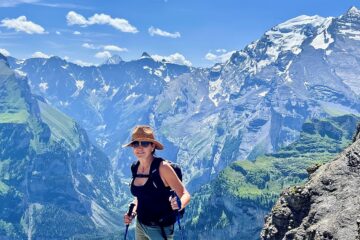 CEO of CorePower Yoga, Niki Leondakis, hiking in Zurchi, surrounded by snowcapped mountains. She explains how to manifest