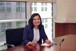 Headshot of Gargi Pal Chaudhuri sitting at a desk in a boardroom and smiling.