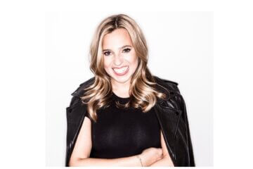 Danielle Weisberg of theSkimm wearing black and smiling at the camera with arms crossed.