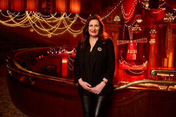 Carmen Pavlovic wearing all black stands on the set of Moulin Rouge! The Musical and smiles.