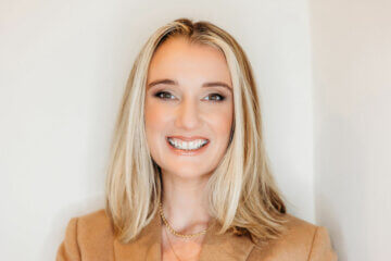 Headshot of Allison Robinson of the Mom Project wearing a brown blazer and smiling at the camera.