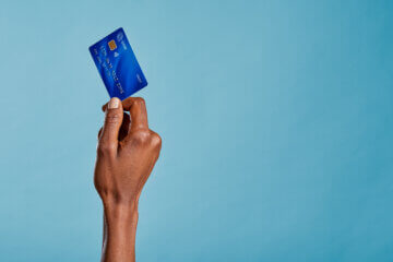 Close up of a woman's hand holding a bank credit card to make a payment with her first credit card