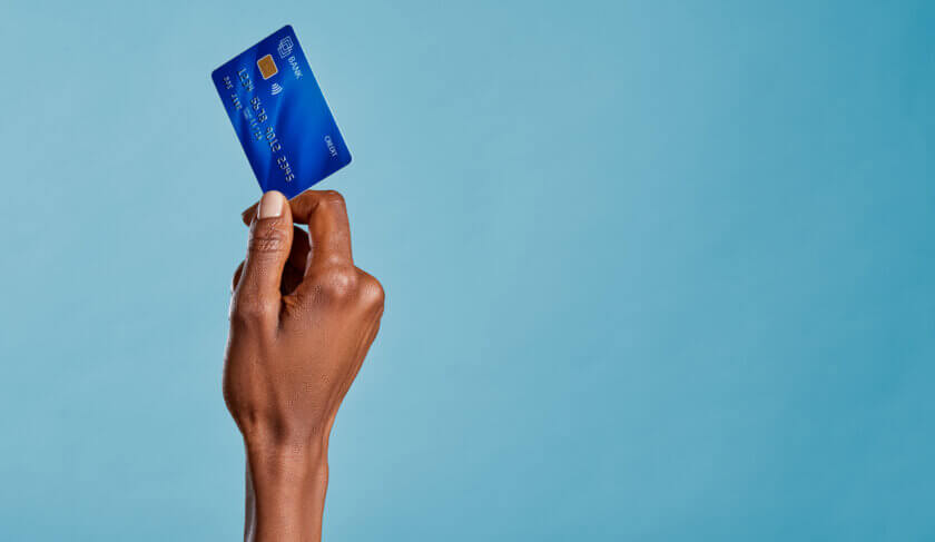 Close up of a woman's hand holding a bank credit card to make a payment with her first credit card